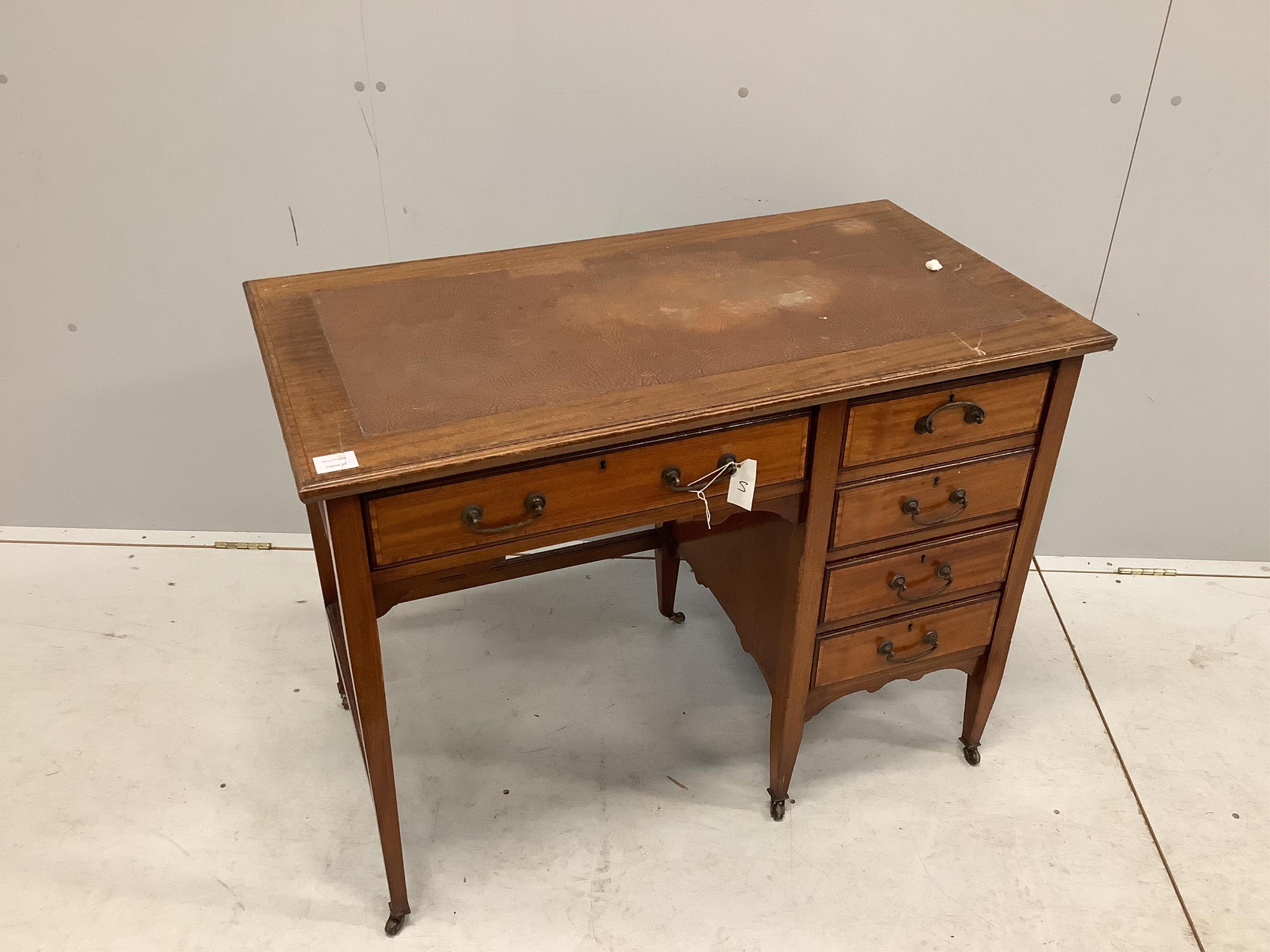 An Edwardian crossbanded mahogany kneehole desk, with moulded edge fitted one frieze drawer and four pedestal drawers, all with brass loop handles, set on square tapered legs with castors, width 99cm, depth 53cm, height